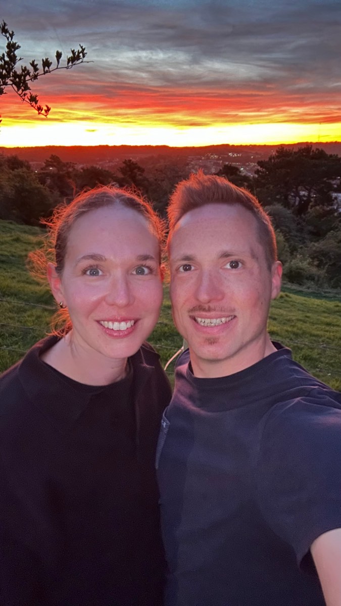 Katha und Chris bei Sonnenuntergang über einer Hügellandschaft